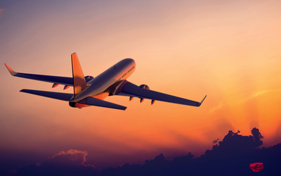 Passenger aircraft flying towards the sunset light wallpaper