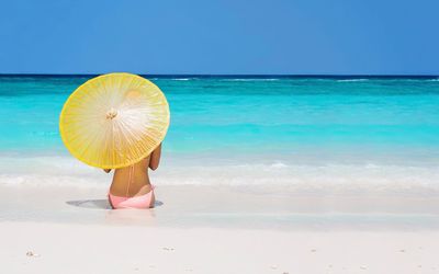 Girl with a yellow umbrella in the sand wallpaper