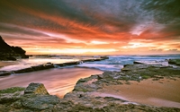 Red clouds upon the mossy rocky ocean shore wallpaper 1920x1200 jpg