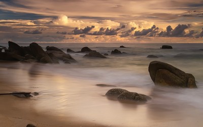 Rocks rising from ocean water to the beautiful sunset wallpaper