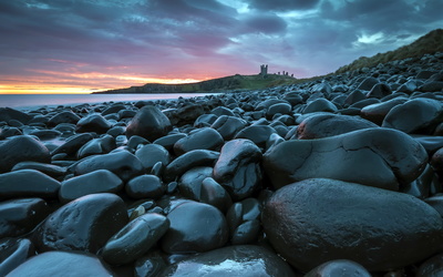 Wet stones on the coast at sunset wallpaper
