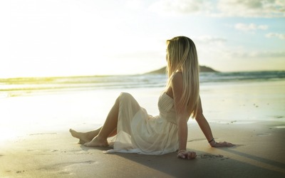 Blonde on a sandy beach watching the sunrise Wallpaper