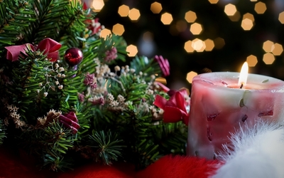 Candle burning near the Christmas tree wallpaper