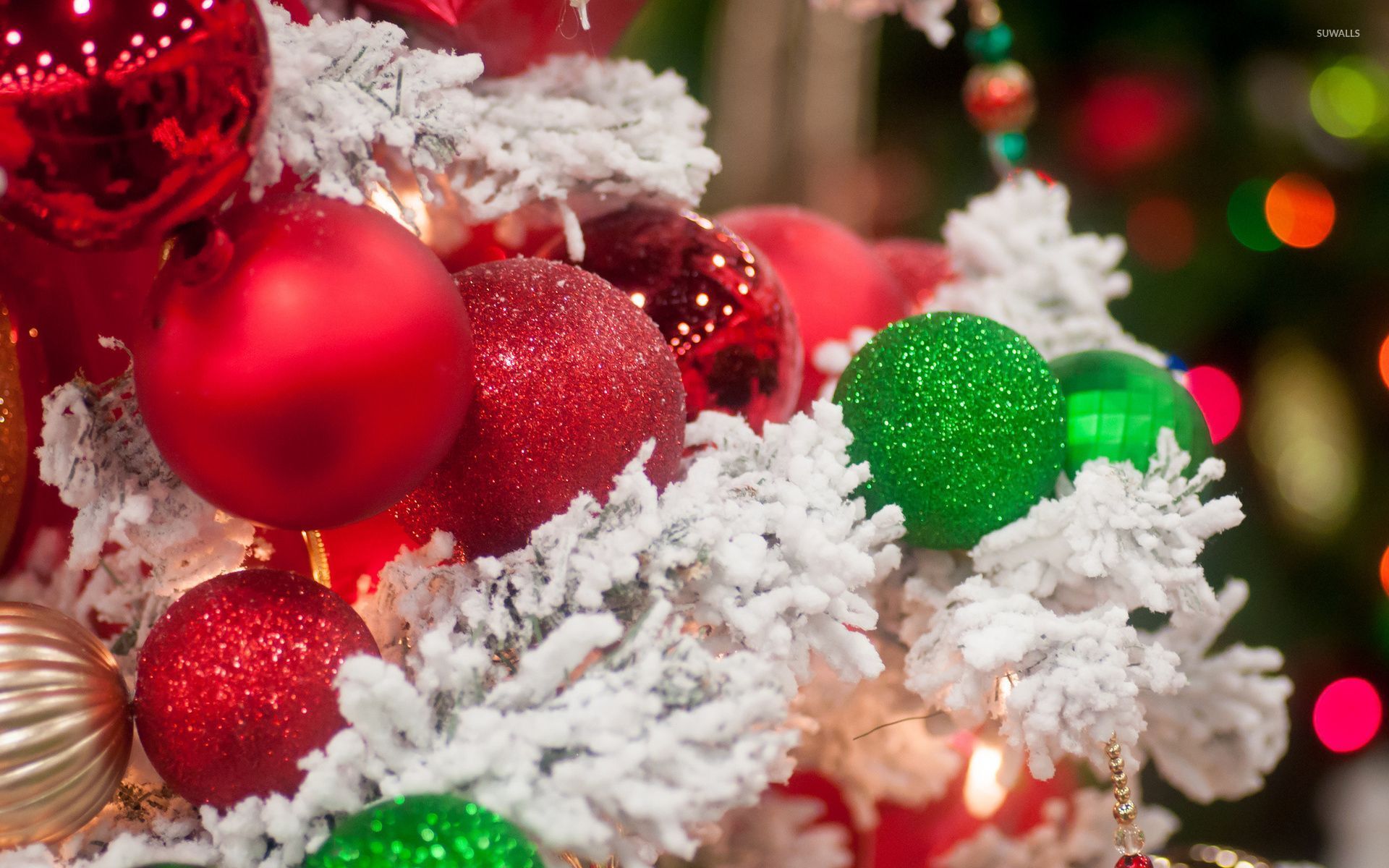 Sparkly red and green baubles on the snowy Christmas tree wallpaper