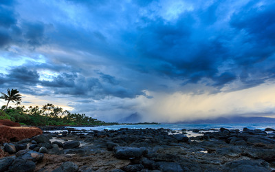 Blue clouds above the rocky shore Wallpaper