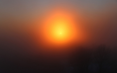 Orange sun piercing through the fog wallpaper