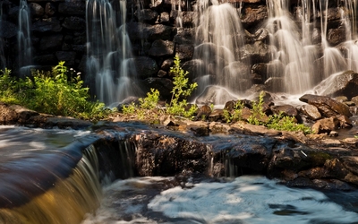 Rocky waterfall reaching to the whriling river wallpaper