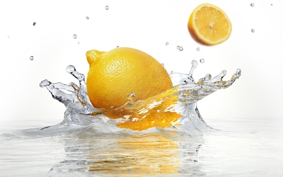 Lemon falling into the crystal clear water wallpaper
