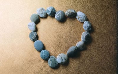 Pebbles shaping a blue heart wallpaper